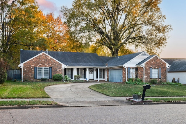 ranch-style home featuring a yard and a garage