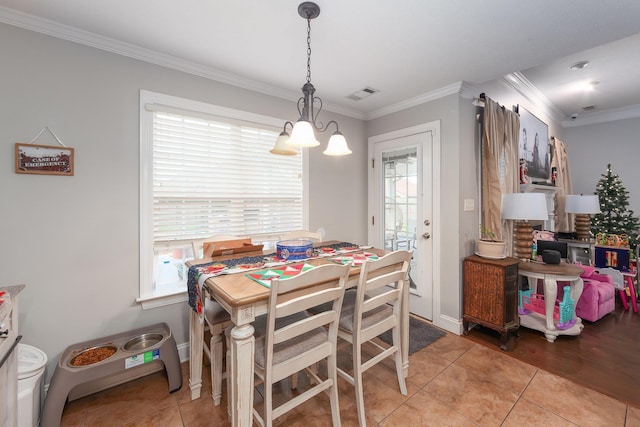 dining area with a notable chandelier, light tile patterned floors, and crown molding