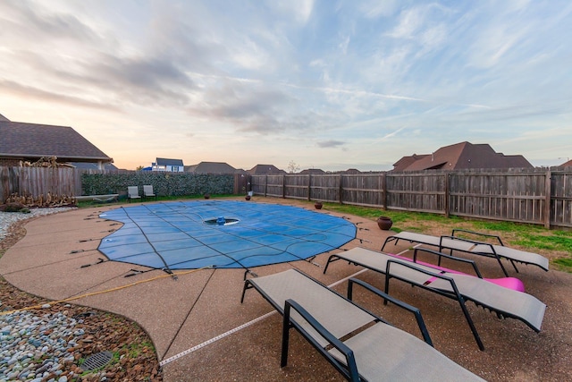 pool at dusk featuring a patio