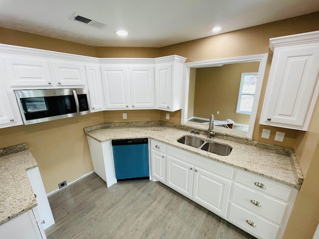 kitchen featuring white cabinets, sink, light hardwood / wood-style flooring, appliances with stainless steel finishes, and light stone counters