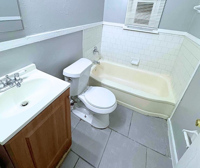 bathroom with a washtub, vanity, tile patterned floors, and toilet