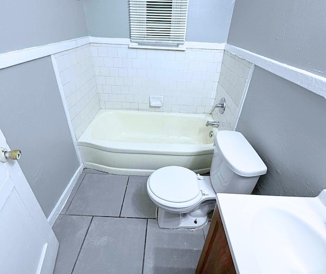 bathroom with a tub to relax in, tile patterned flooring, vanity, and toilet