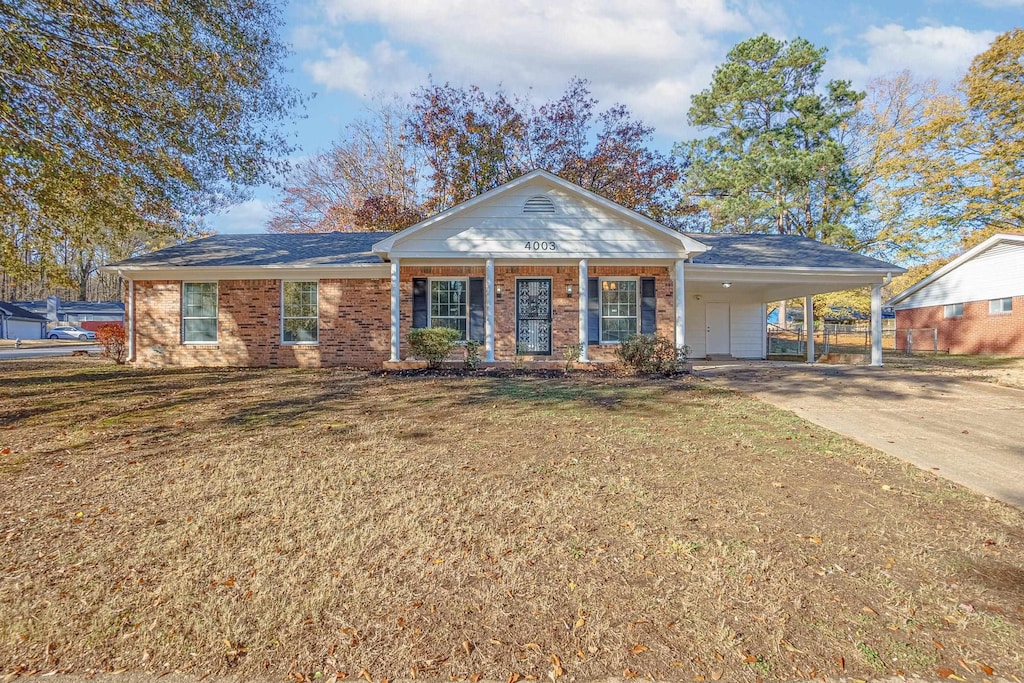 ranch-style house with a carport, a porch, and a front lawn