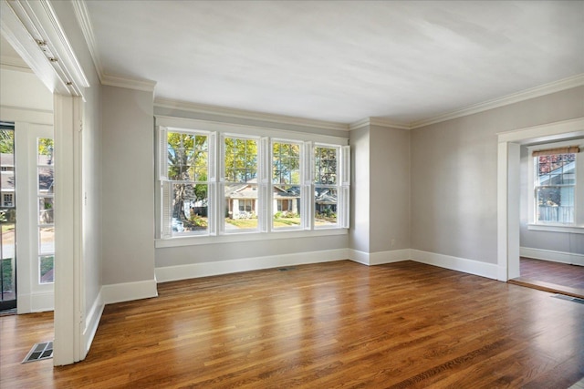 spare room featuring hardwood / wood-style floors and crown molding