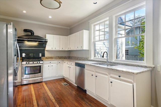 kitchen featuring dark wood-type flooring, exhaust hood, sink, appliances with stainless steel finishes, and white cabinetry