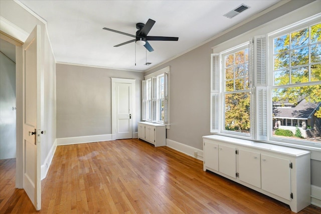 unfurnished bedroom featuring multiple windows, ceiling fan, crown molding, and light hardwood / wood-style floors