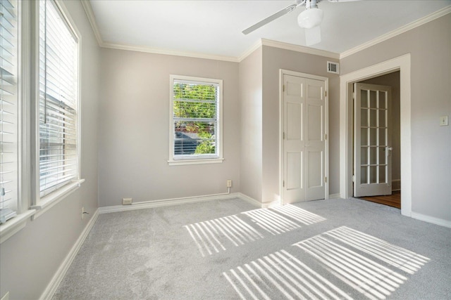 unfurnished bedroom with ceiling fan, light colored carpet, and ornamental molding