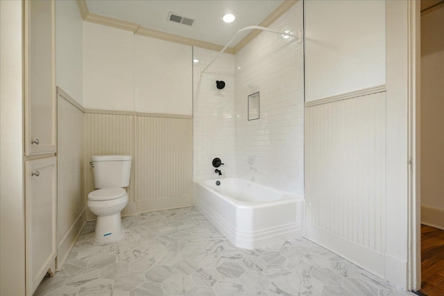 bathroom featuring crown molding, tiled shower / bath, and toilet