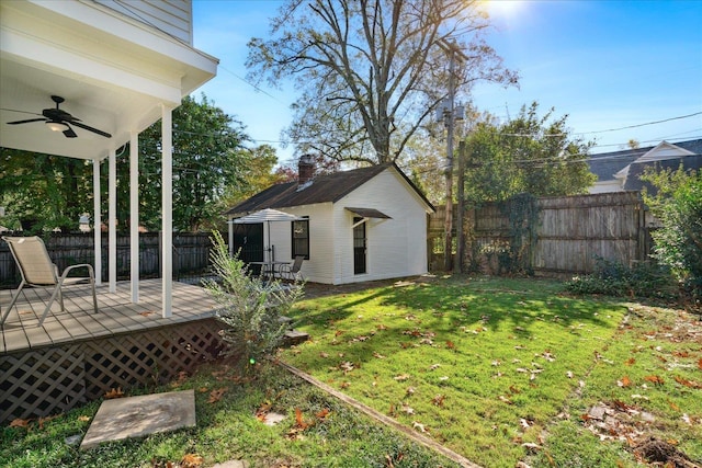 view of yard with ceiling fan and a deck