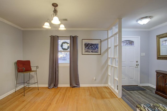 entrance foyer featuring crown molding, an inviting chandelier, and light wood-type flooring