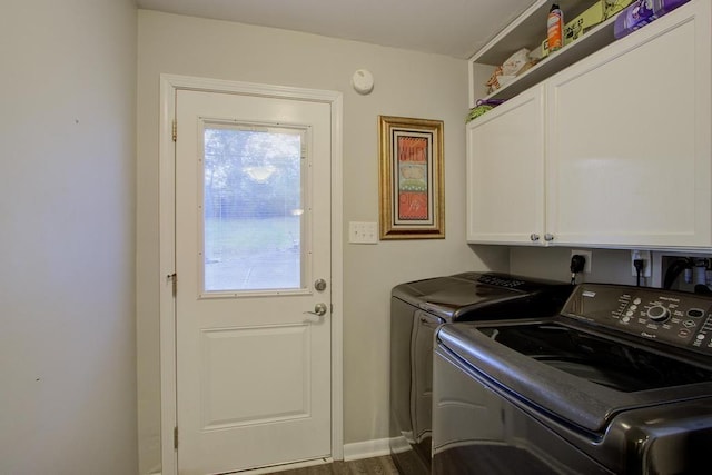 clothes washing area with hardwood / wood-style floors, cabinets, and washing machine and dryer