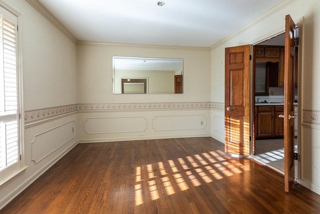 spare room with dark wood-style flooring, wainscoting, and crown molding