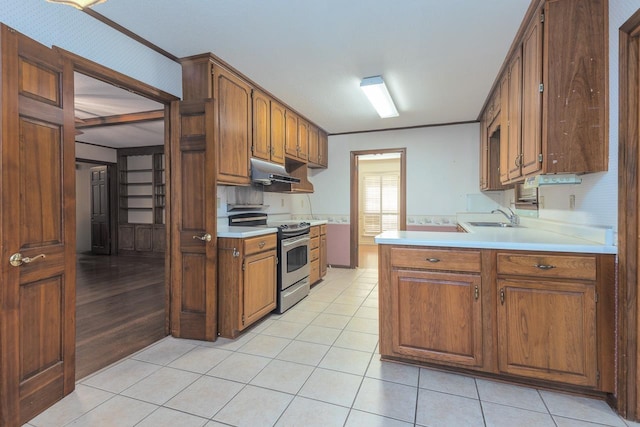 kitchen with brown cabinets, stainless steel electric range, light countertops, under cabinet range hood, and a sink