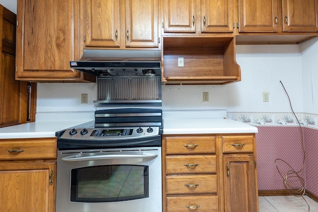 kitchen featuring wallpapered walls, brown cabinetry, stainless steel electric stove, extractor fan, and light countertops