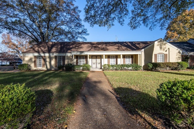 ranch-style home featuring a front lawn and brick siding