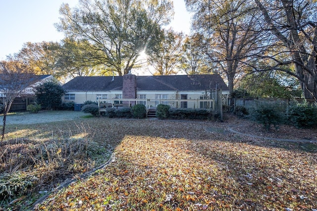 view of front of property with a chimney and fence