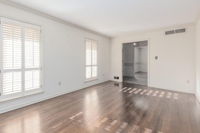 unfurnished bedroom with baseboards, visible vents, dark wood finished floors, and crown molding