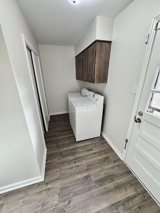 clothes washing area featuring cabinets, dark hardwood / wood-style flooring, and washer and clothes dryer