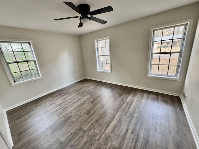 spare room featuring ceiling fan, a healthy amount of sunlight, and dark hardwood / wood-style floors