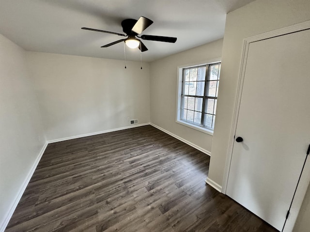 unfurnished room with ceiling fan and dark wood-type flooring