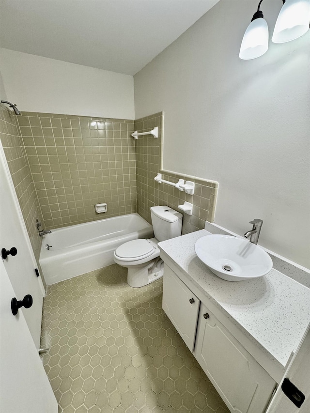 full bathroom with vanity, tile patterned floors, tiled shower / bath combo, and toilet