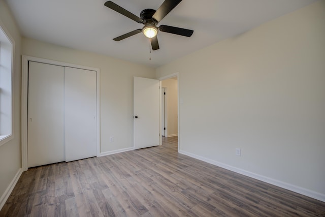 unfurnished bedroom featuring ceiling fan, a closet, and light hardwood / wood-style flooring