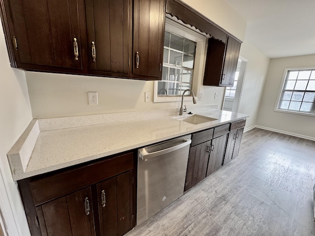 kitchen with dishwasher, dark brown cabinets, light wood-type flooring, and sink