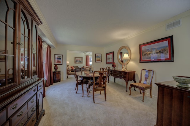 carpeted dining area featuring ceiling fan and crown molding