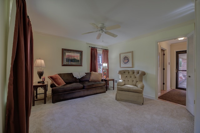 carpeted living room with ceiling fan and ornamental molding