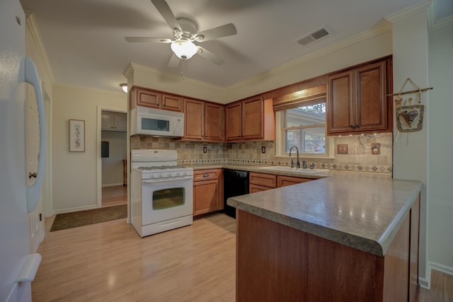 kitchen featuring sink, kitchen peninsula, light wood-type flooring, white appliances, and ornamental molding