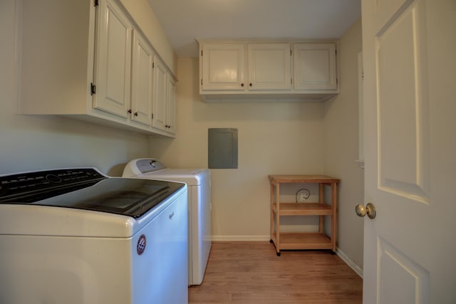 laundry room featuring cabinets, electric panel, separate washer and dryer, and light hardwood / wood-style flooring