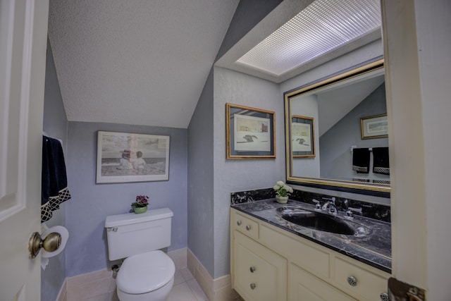 bathroom with tile patterned floors, vanity, toilet, and lofted ceiling