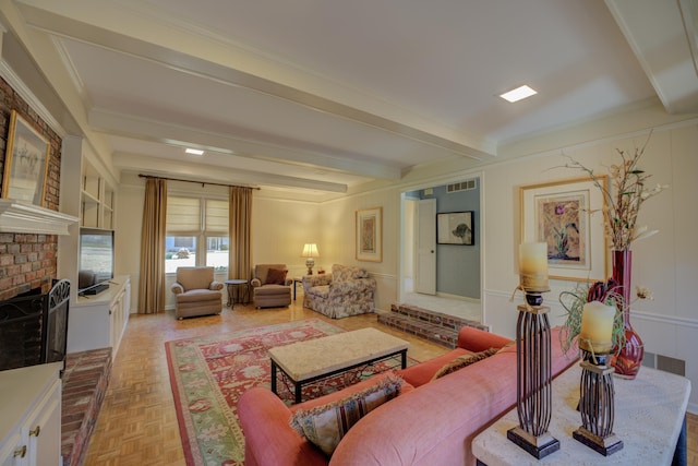 living room featuring beamed ceiling, crown molding, a fireplace, and light parquet flooring