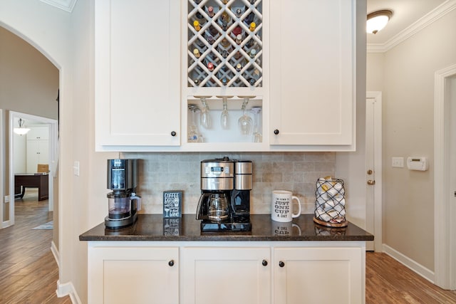 bar featuring white cabinets and light hardwood / wood-style flooring