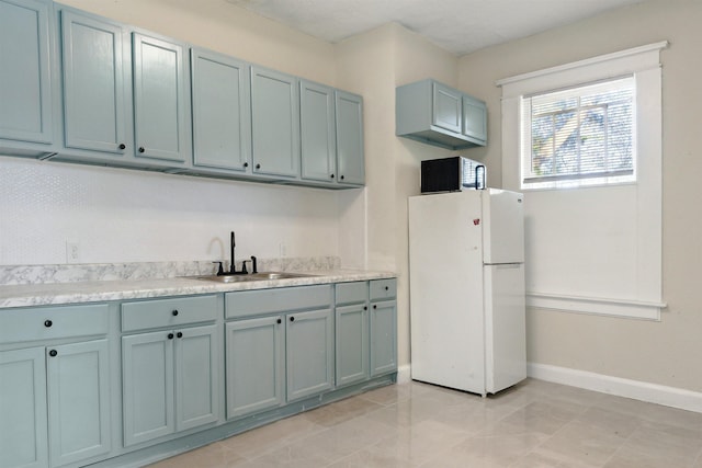 kitchen with sink, light tile patterned floors, and white refrigerator