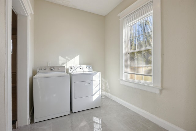 washroom with light tile patterned flooring and washer and dryer