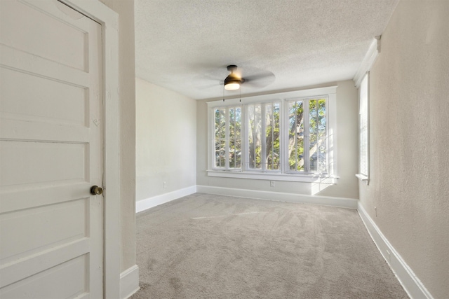 carpeted empty room featuring a textured ceiling and ceiling fan