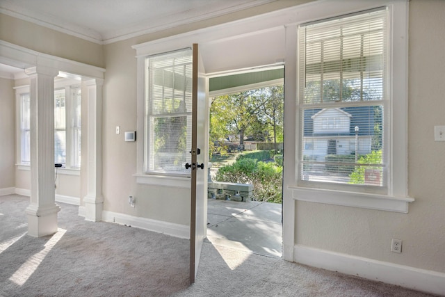 entryway featuring light carpet, decorative columns, and a wealth of natural light