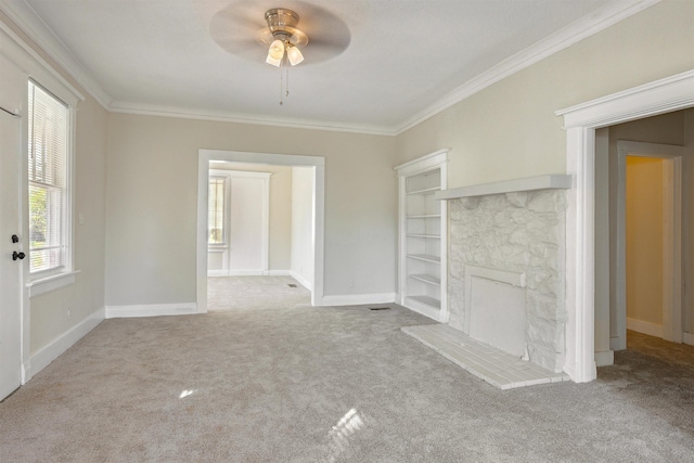 unfurnished living room with a fireplace, light colored carpet, ceiling fan, and crown molding