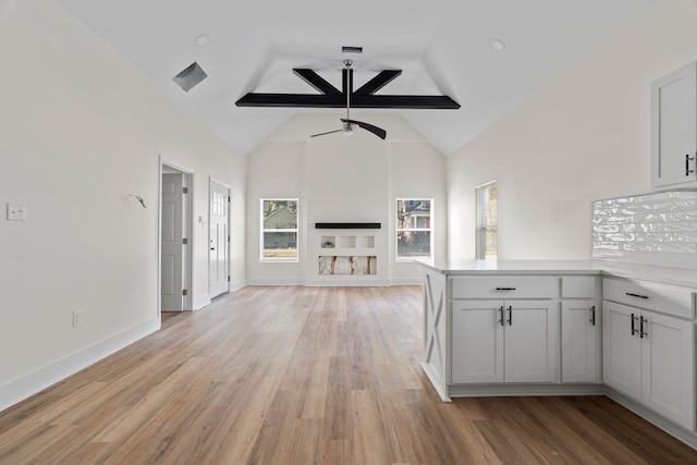 unfurnished living room featuring vaulted ceiling with beams, light hardwood / wood-style floors, and ceiling fan