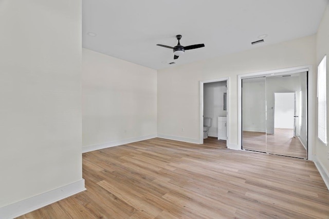 unfurnished bedroom featuring ceiling fan, light wood-type flooring, and connected bathroom