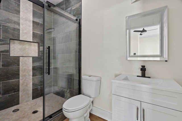 bathroom featuring vanity, a shower with shower door, and toilet