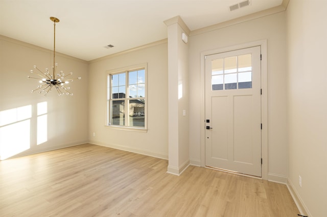 entryway with ornamental molding, an inviting chandelier, light wood-type flooring, and a wealth of natural light