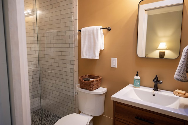 bathroom featuring vanity, toilet, and a shower with door