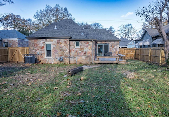 rear view of property with central air condition unit, a yard, and a wooden deck