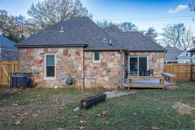 rear view of property featuring a lawn and a deck