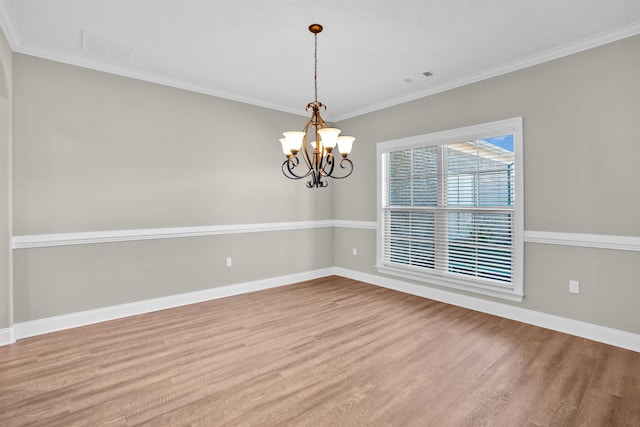 unfurnished room featuring hardwood / wood-style floors, an inviting chandelier, and ornamental molding