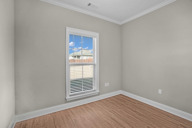 empty room featuring hardwood / wood-style flooring and ornamental molding