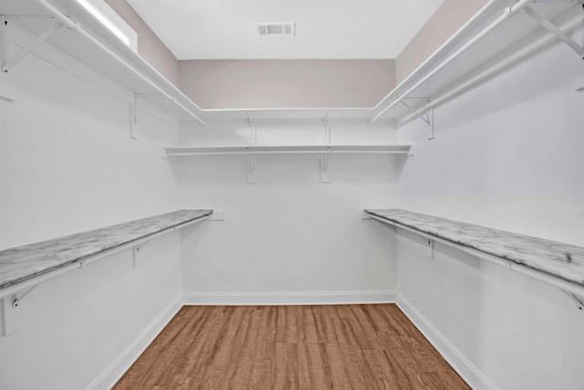 spacious closet with hardwood / wood-style flooring