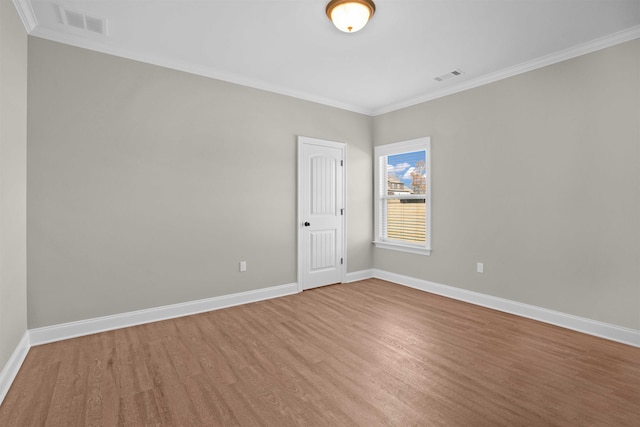 empty room featuring hardwood / wood-style flooring and ornamental molding